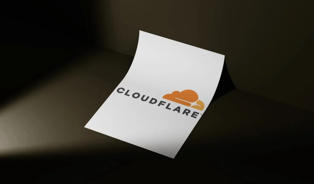 Floating white sheet featuring the Cloudflare logo and name in orange and black text against a dark background.